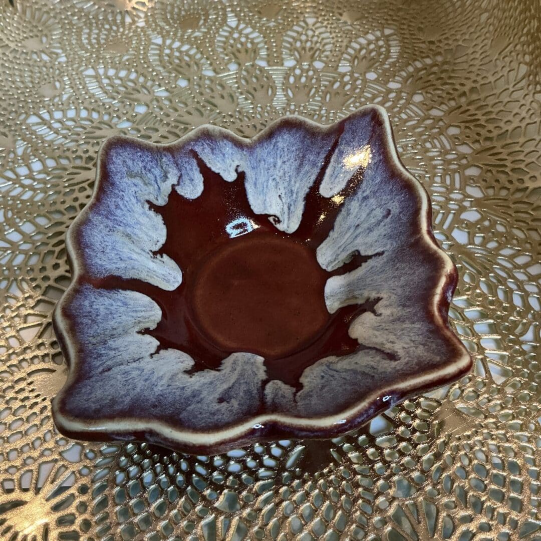 A small bowl with a leaf design on it