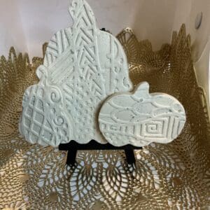 A white pumpkin and a white tree on a stand