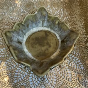 A bowl that is made of leaves on top of a table.