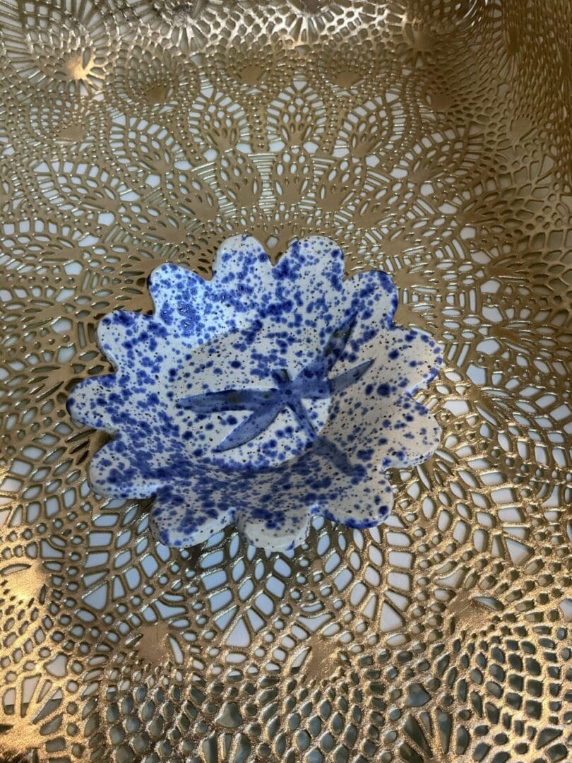 A blue and white bowl sitting on top of a lace doily.