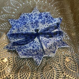 A blue and white paper plate with a bow on top of it.