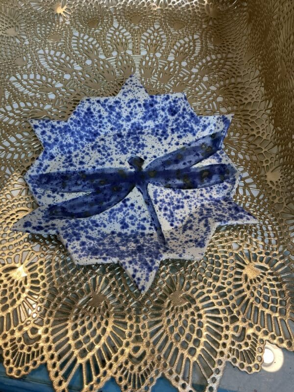 A blue and white paper plate with a bow on top of it.