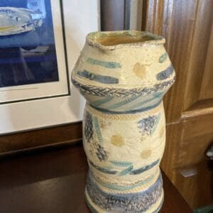 A vase sitting on top of a wooden table.