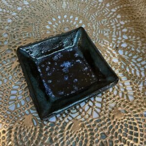 A black square plate sitting on top of a table.