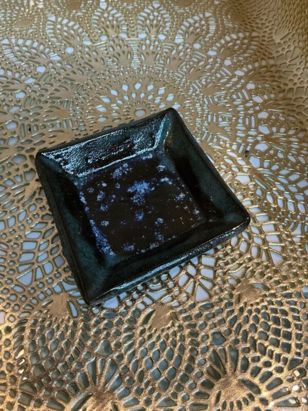 A black square plate sitting on top of a table.