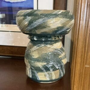 A vase sitting on top of a wooden table.