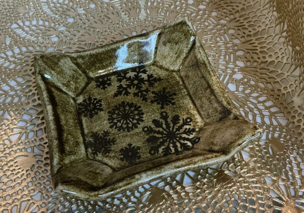 A square plate with a pattern of flowers on it.