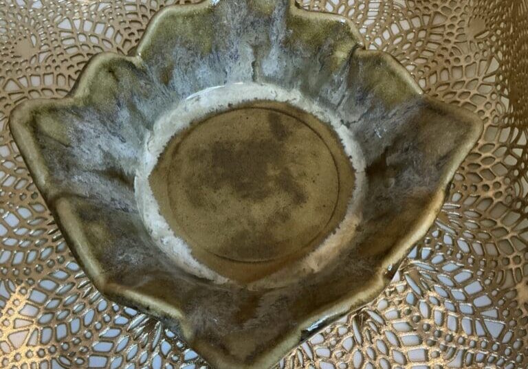 A bowl that is made of leaves on top of a table.