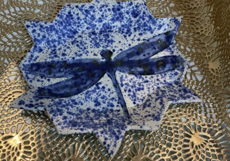 A blue and white paper plate with a bow on top of it.