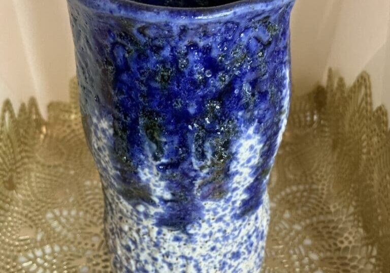 A blue vase sitting on top of a table.