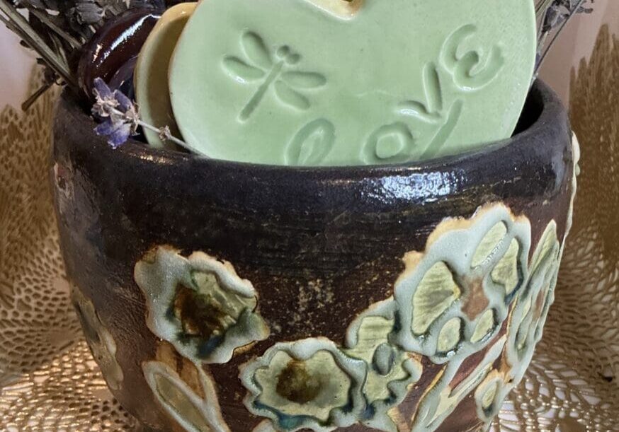 A brown vase with some green cookies in it